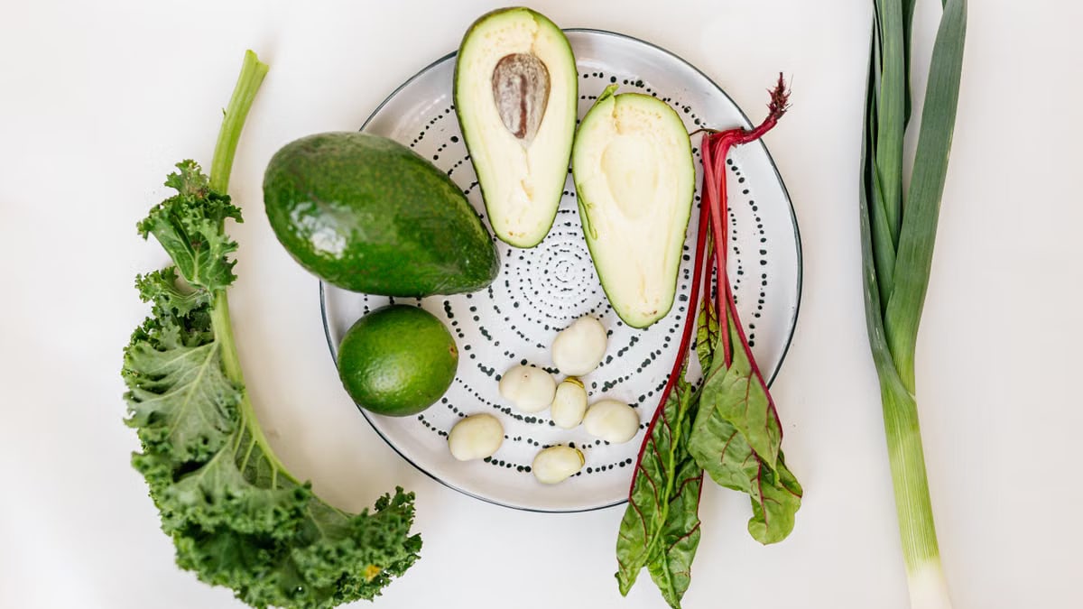 A vibrant flat lay of fresh vegetables and avocado on a plate.